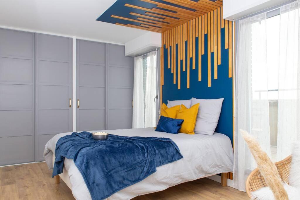een slaapkamer met een bed met een blauwe en gele muur bij Perle d'Évasion - Cinéma privée - 15 minutes Paris in Athis-Mons