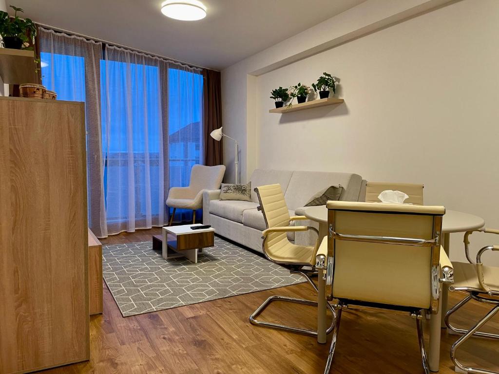 ein Wohnzimmer mit einem Sofa, einem Tisch und Stühlen in der Unterkunft Apartmán Astra in Sezimovo Ústí