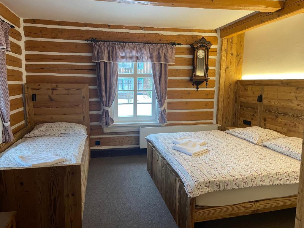 1 dormitorio con 2 camas y ventana en Penzion Brnenka, en Špindlerův Mlýn