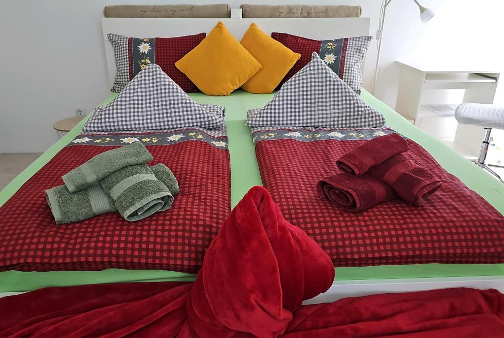 a bed with red and green blankets and pillows at Naturgespür in Wien in Vienna