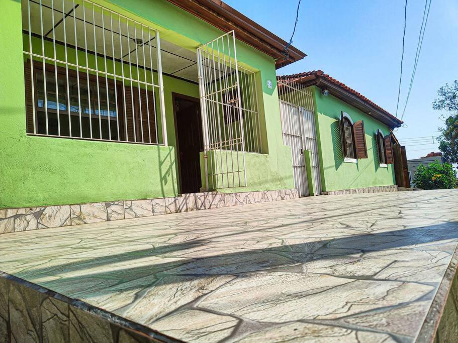 uma casa verde com um passeio de pedra em frente em Casa 54 em São Sebastião