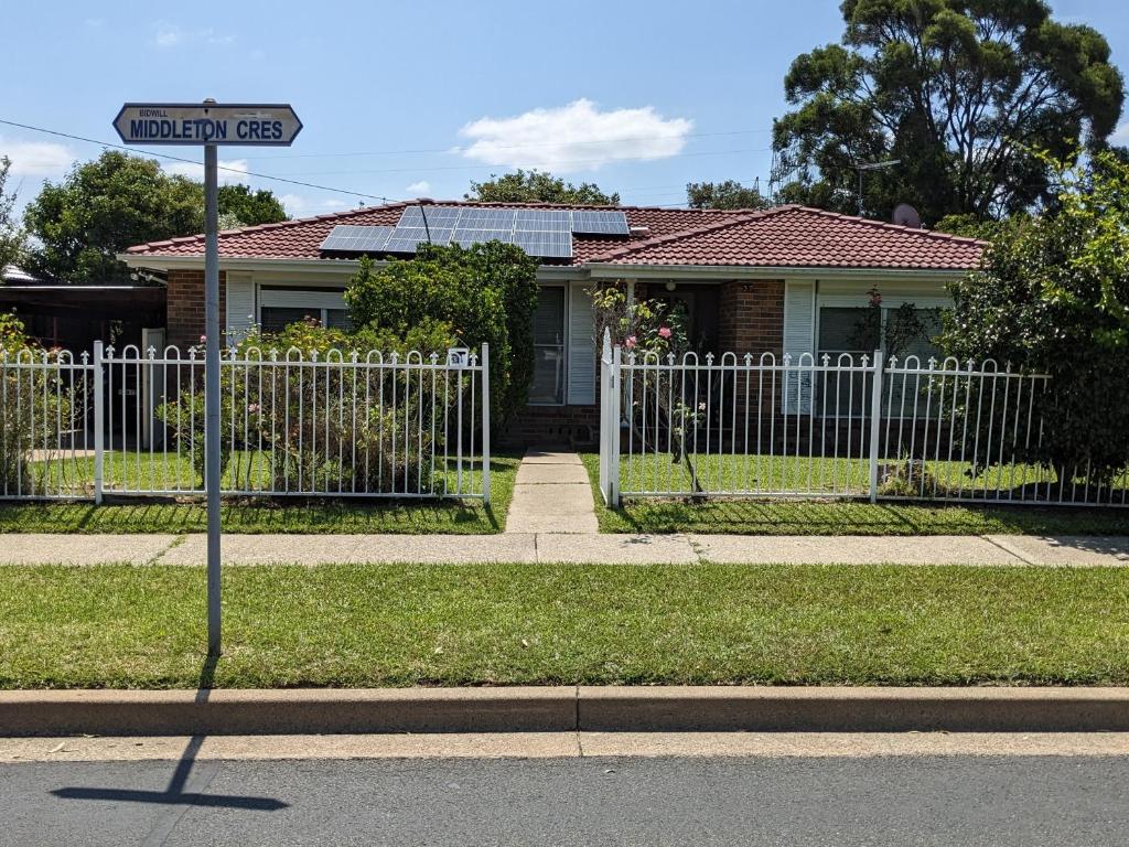 a street sign in front of a house with a fence at #BIDWILL GARDENS ON MIDDLETON# Private Room King Size Bed OR Open Lounge Room Floor Mattress SHARED Bathroom FREE Kitchen Essentials Fast NBN WIFI HDTV KAYO Sports Youtube FREE Laundry Facilities Transportation and Meal Services Available On Request in Sydney