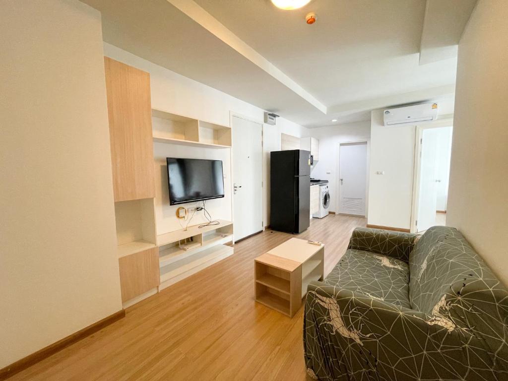 - un salon avec un canapé et une télévision dans l'établissement 2BR Apartment, à Bangkok