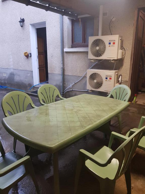 a green table and chairs in a room at Chez Nino wifi gratuit in Beaulieu-sur-Loire