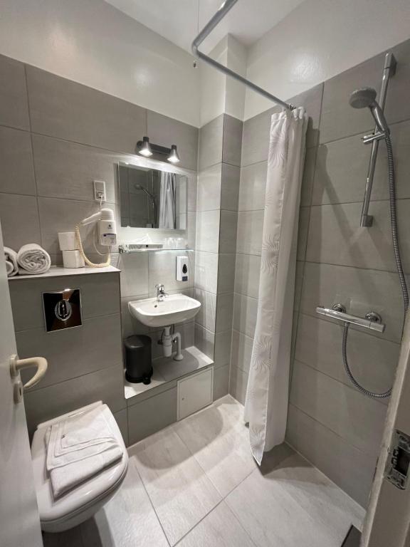 een badkamer met een douche, een toilet en een wastafel bij Hotel Skandia in Helsingør