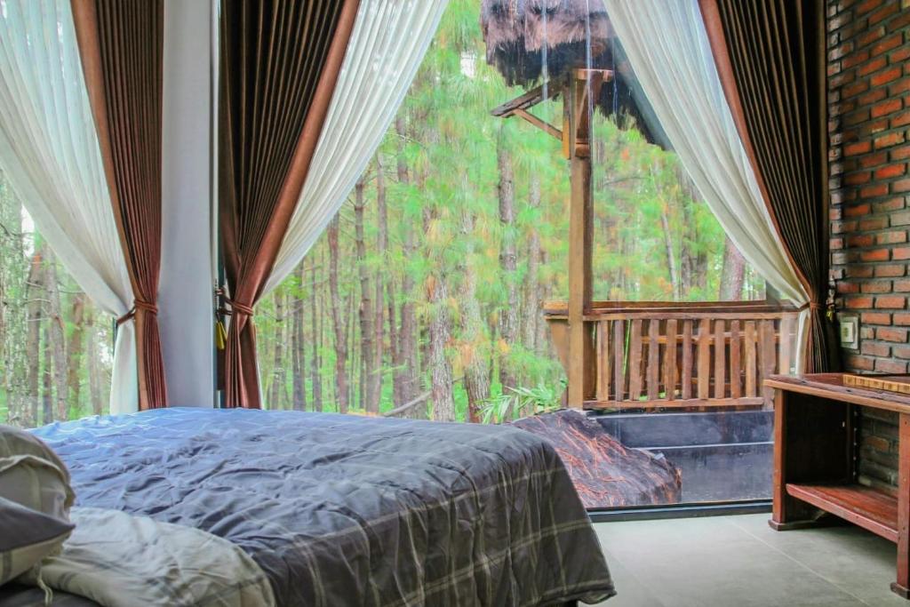 a bedroom with a bed and a large window at AAA, Omah Kayu, Exclusive Bromo Tour Villa, Managed by Triple A Tour, Including Bromo Jeep Tour and Airport Shuttle in Ngadisari