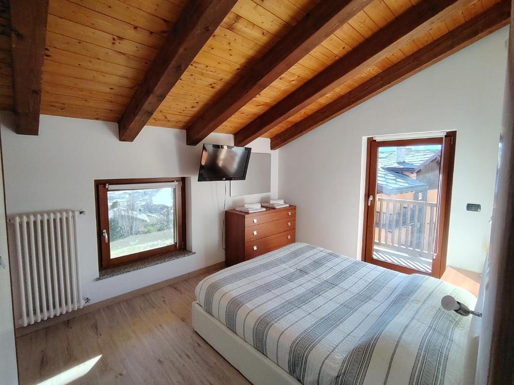 a bedroom with a bed and a tv and a window at CasaSolar Saintchristophe a 2 minuti da Aosta in Aosta