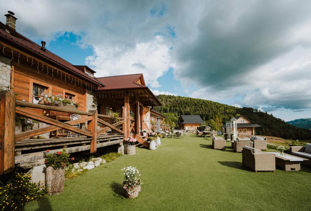 a resort yard with chairs and a building at Penzión Zbojnícky Halaš in Tisovec