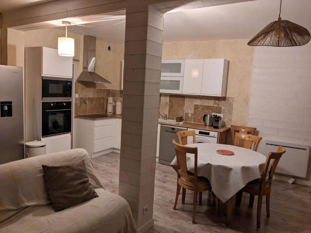 kuchnia i jadalnia ze stołem i kanapą w obiekcie Halte Loire w mieście Saumur