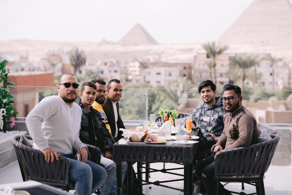 a group of men sitting at a table on a patio at Tuya pyramids inn in Cairo