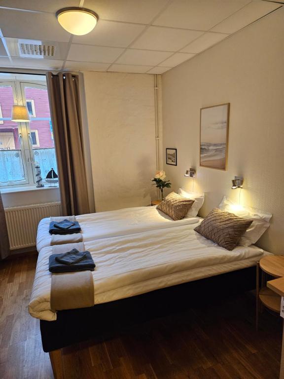 1 dormitorio con 1 cama grande y toallas. en Hotell Alderholmen, en Gävle