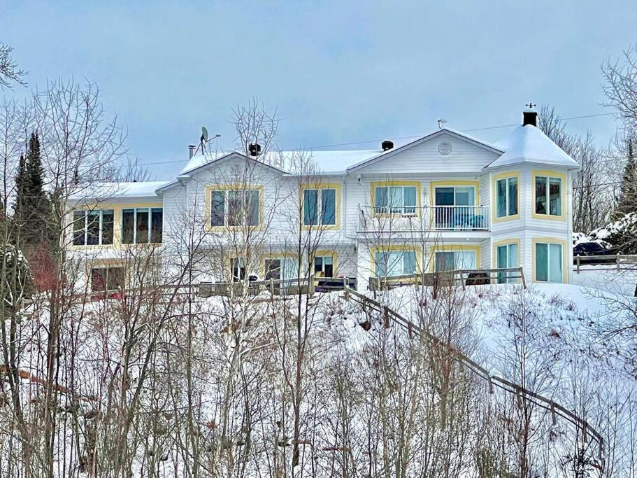 Ferme-NeuveにあるFull Chalet - 6 Bdrm Private / Beachfront / Kayaksの雪に覆われた丘の上の大きな白い家