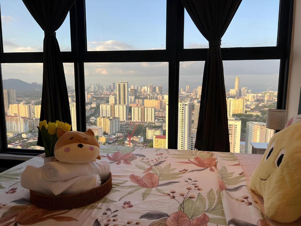 a bed with a view of a city from a window at Urban Suites by PerfectSweetHome with Home Feel L in Jelutong