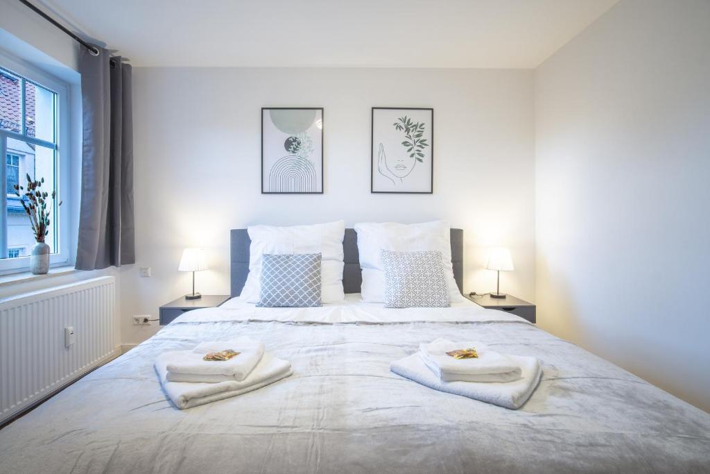 een slaapkamer met een groot wit bed en handdoeken bij CoView - ruhige Design Wohnung - 2 Schlafzimmer - voll ausgestattete Küche in Dresden