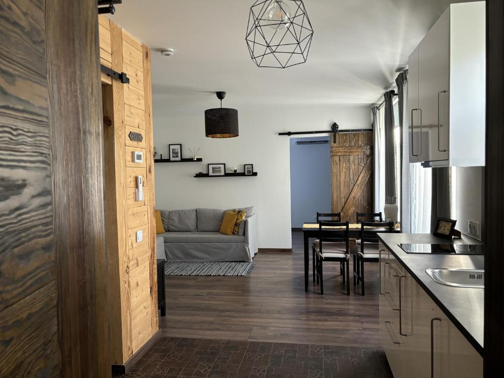 a kitchen and living room with a couch and a table at Cozy seaside park apartment in Liepāja