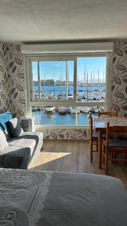 a bedroom with a view of a harbor with boats at Studio cosy climatisé vue sur port in Cap d'Agde