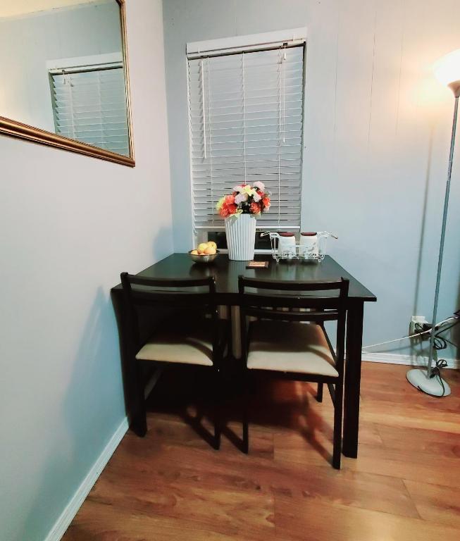 a black table with a vase of flowers on it at Merj's Guest House in Wolesly in Winnipeg