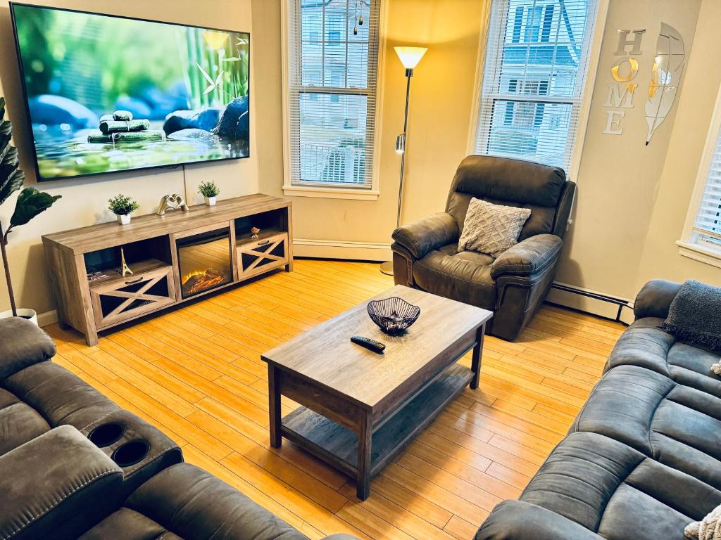 sala de estar con 2 sofás y TV en Bright, Stylish & Cozy 2Bed Unit w/Backyard & Grill Close to NYC!, en Haledon