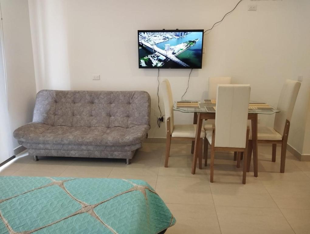 uma sala de estar com um sofá e uma mesa com uma televisão em Hermoso Aparatasuite en Salinas del Mar- Santa Marta em Santa Marta