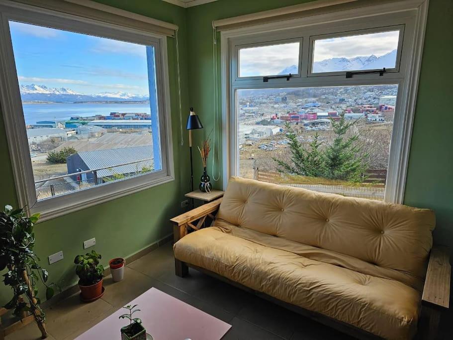 ein Wohnzimmer mit Couch und großem Fenster in der Unterkunft Departamento en zona residencial in Ushuaia