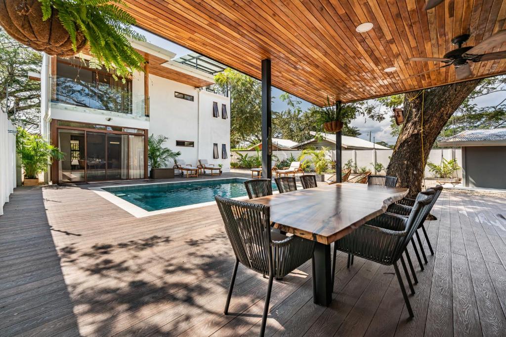un patio con tavolo e sedie in legno e una piscina di Tropical Escape Private Pool & Outdoor Kitchen a Sardinal
