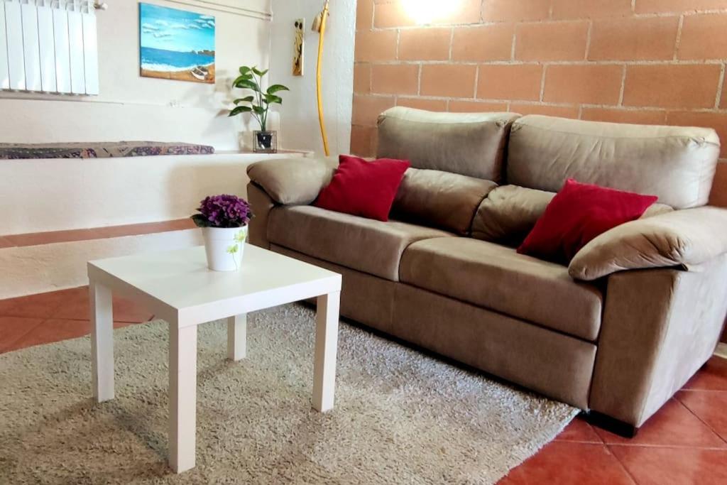 ein Wohnzimmer mit einem Sofa und einem Tisch in der Unterkunft Apartamento entero en la montaña in El Pont de Vilomara