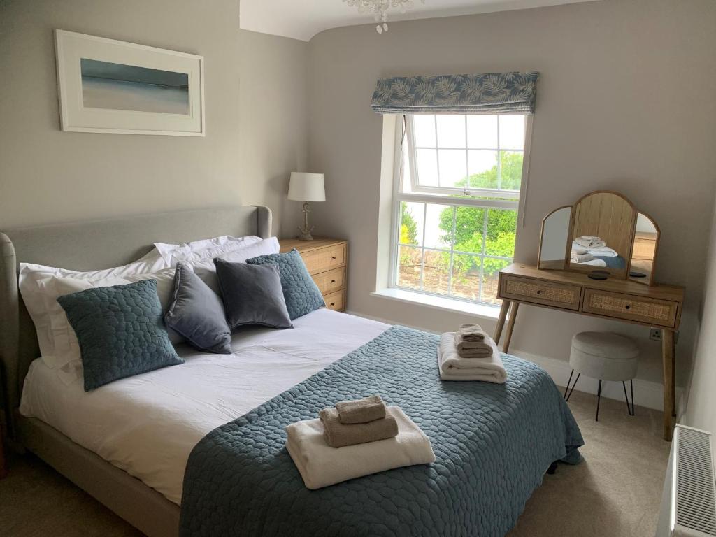 a bedroom with a bed with towels on it at Applestow Cottage in Northam