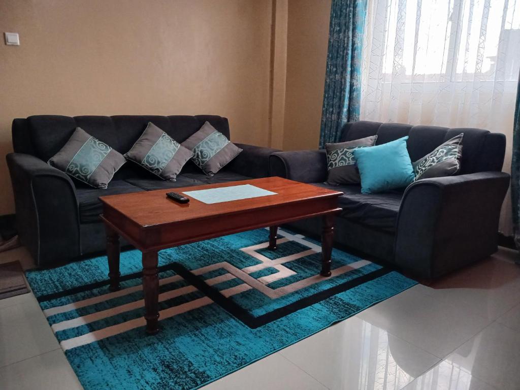 uma sala de estar com um sofá e uma mesa de centro em J's Nest em Kericho