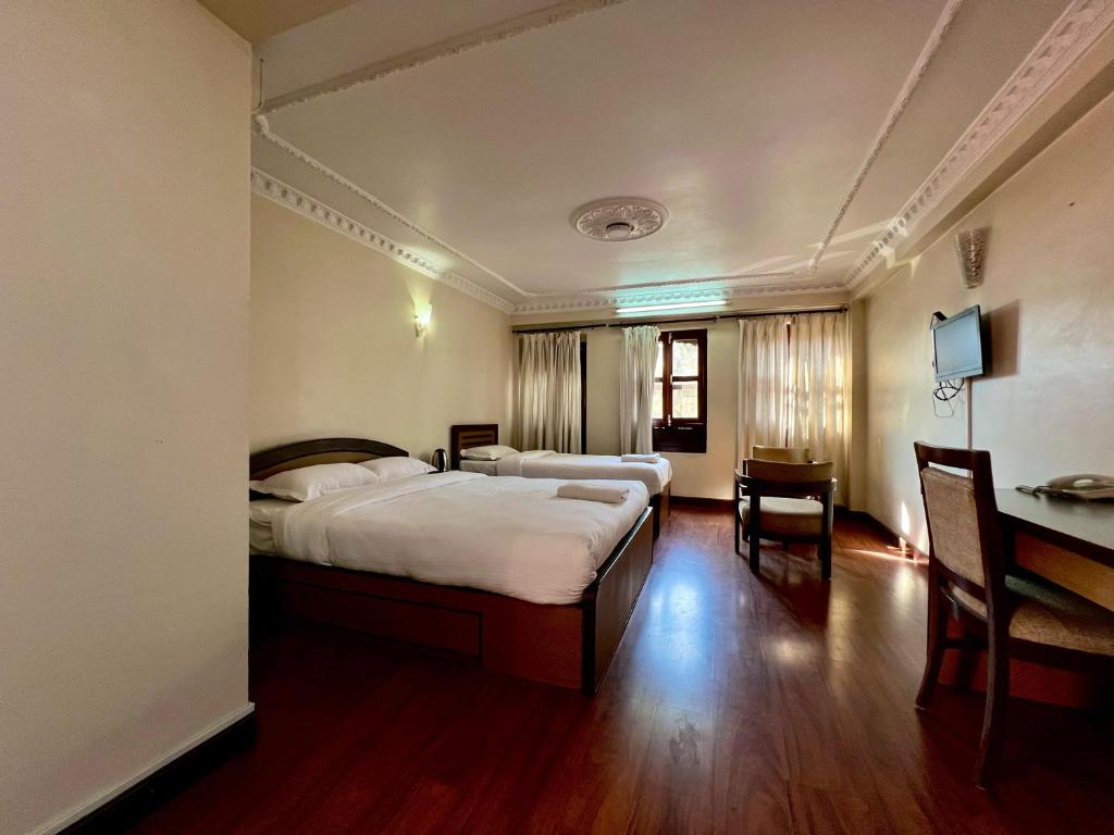 a hotel room with a bed and a desk at Taleju Grand Hotel in Bhaktapur