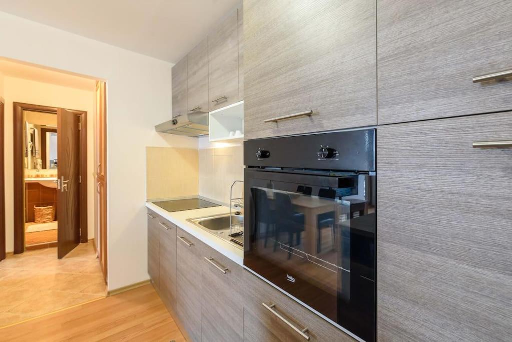 a kitchen with a black oven and a sink at Bansko Ski & Relax Apartment in Bansko