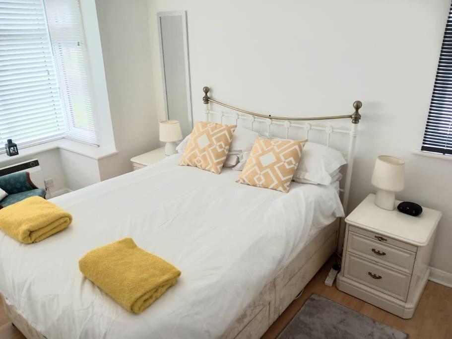 una camera da letto con un letto bianco con cuscini gialli di 1 Bed Bognor Apartment 300 yrds from beach a Bognor Regis