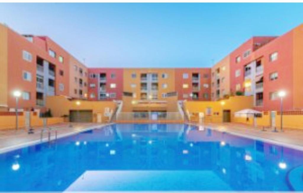 uma grande piscina em frente a alguns edifícios de apartamentos em APARTAMENTO NAIR em Candelaria