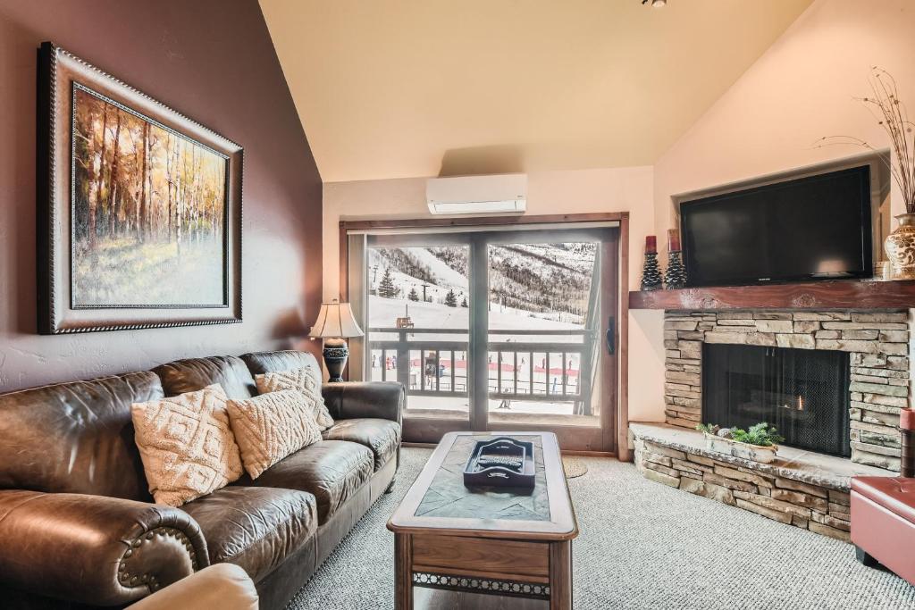 - un salon avec un canapé en cuir et une cheminée dans l'établissement Village Loft Escape 35 Ski-In Ski-Out at Park City Mountain condo, à Park City