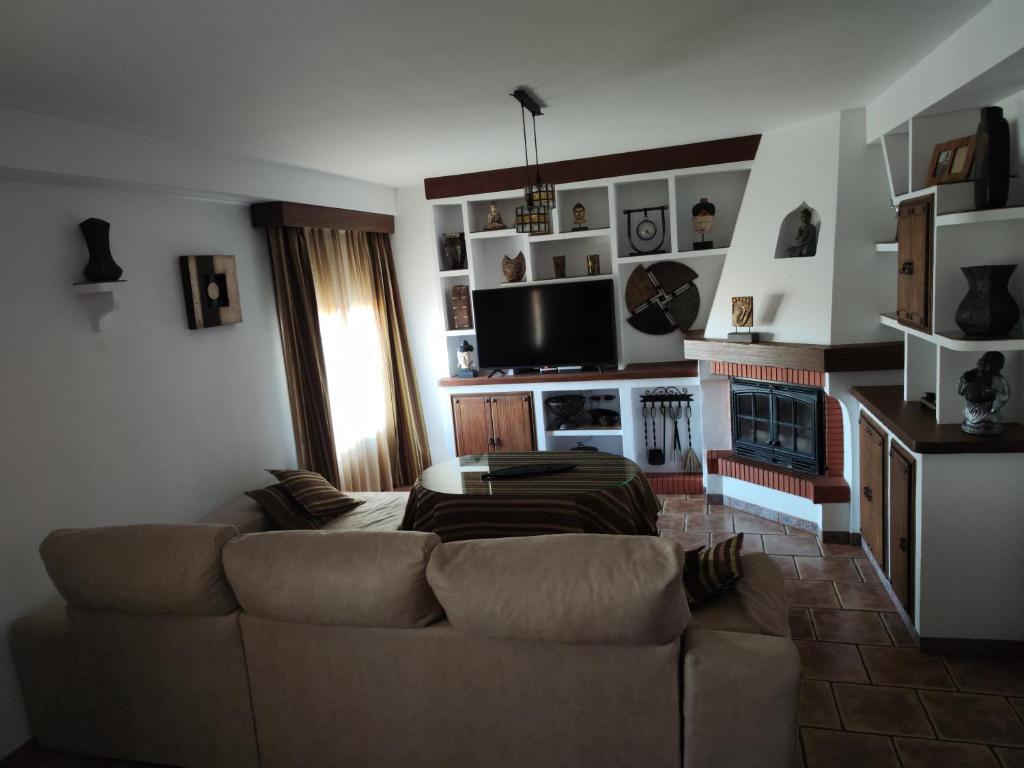 uma sala de estar com um sofá e uma lareira em CASA LAURA em Iznájar