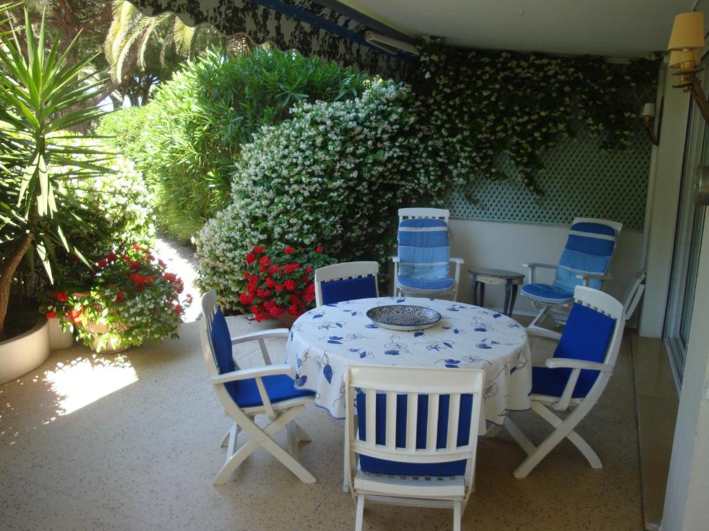 - une table avec des chaises bleues et blanches sur la terrasse dans l'établissement Cannes Croisette Two bedrooms, à Cannes
