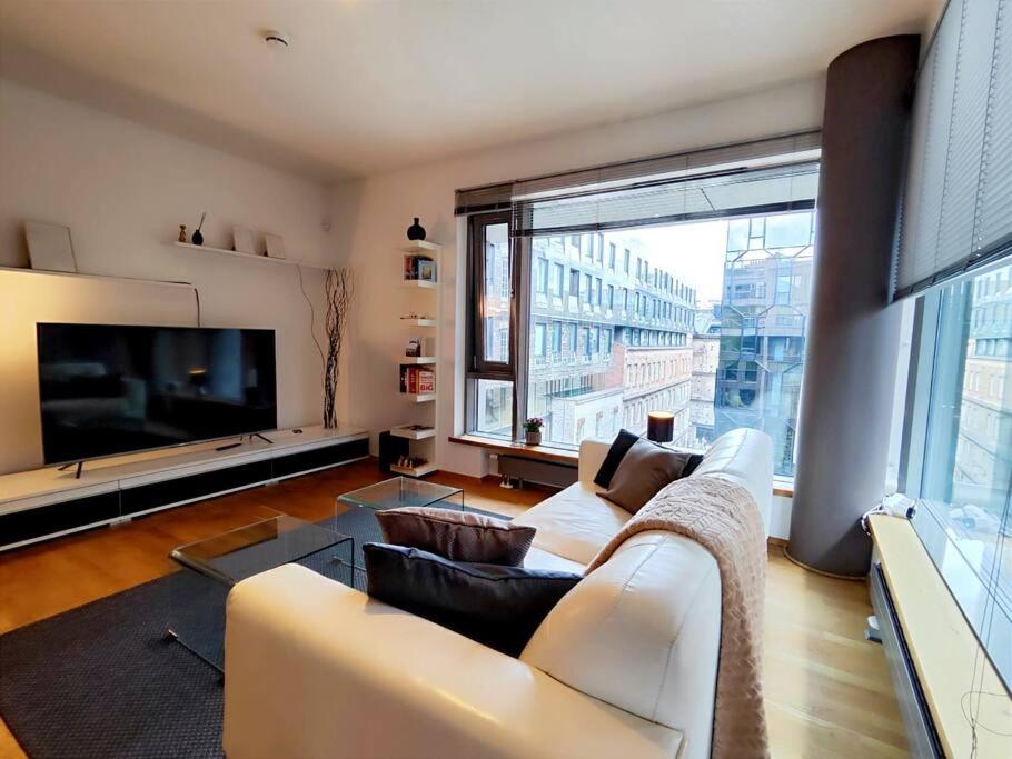 uma sala de estar com um sofá branco e uma grande janela em Enjoy luxury and convenience @best area of Tallinn em Talin