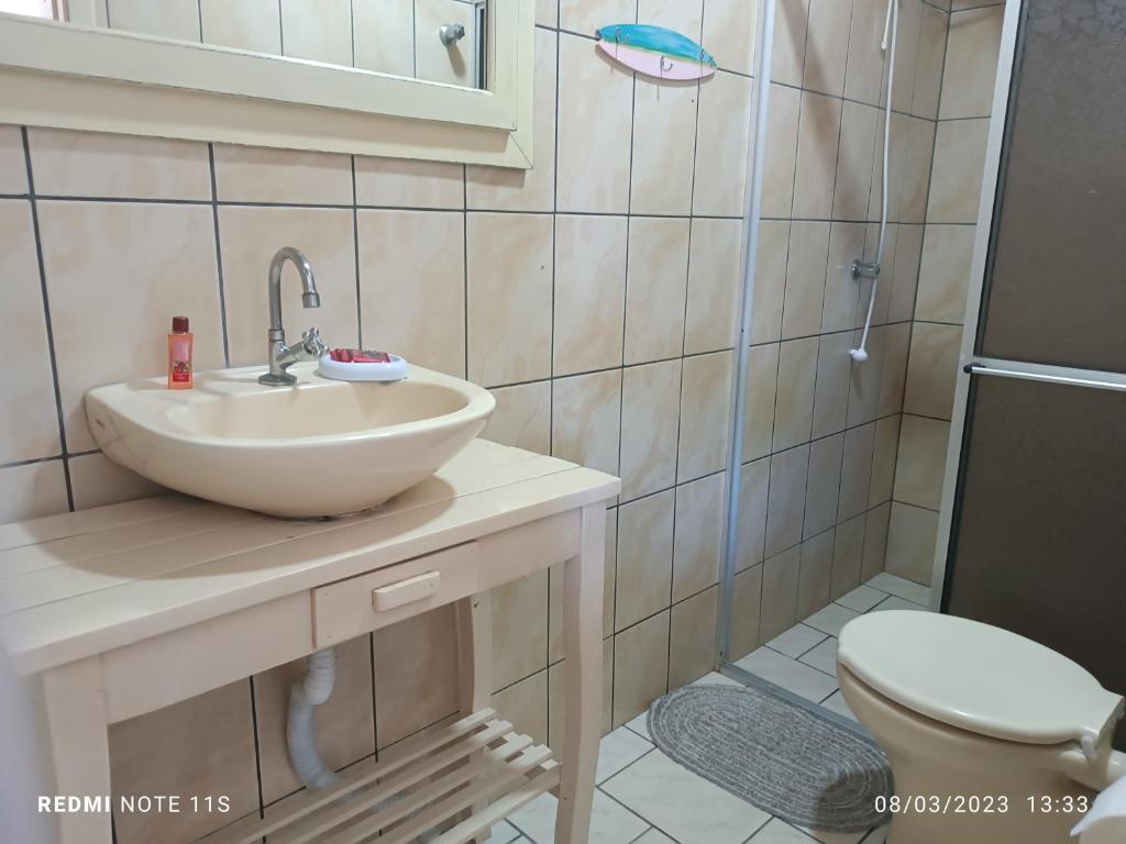 uma casa de banho com um lavatório e um WC em Pousada Anturio em Barra Velha