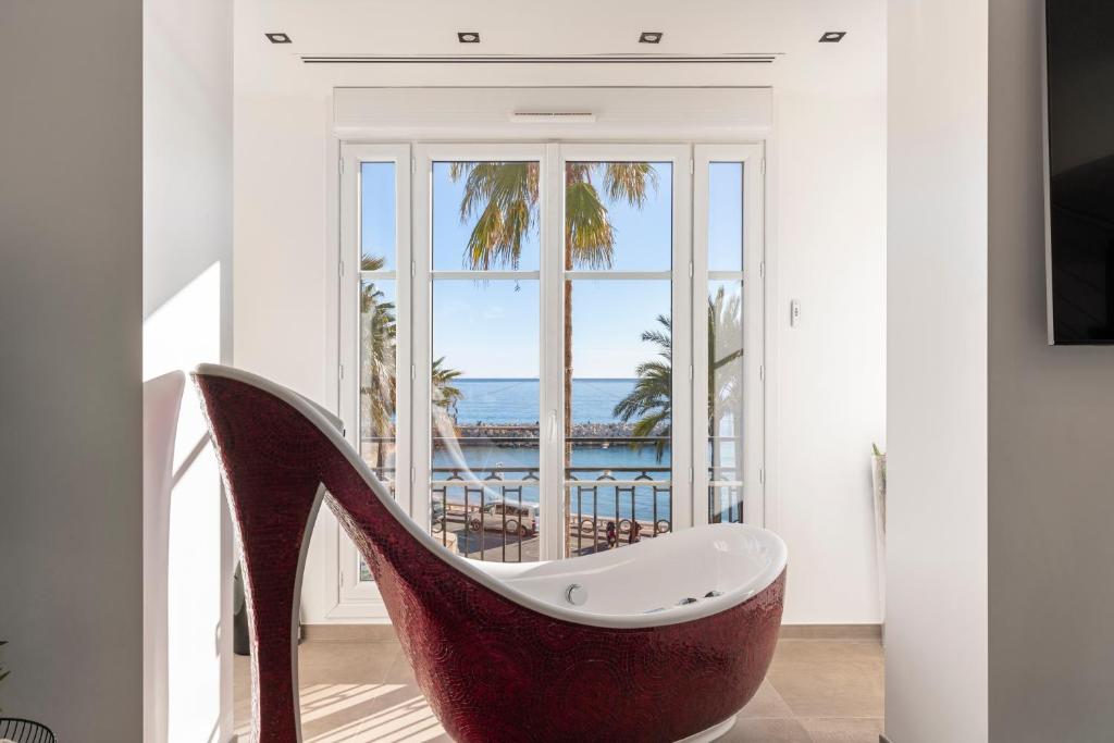 Cette chambre dispose d'une baignoire et d'une grande fenêtre. dans l'établissement 8H - Appartement Penthouse 4 chambres, à Cannes