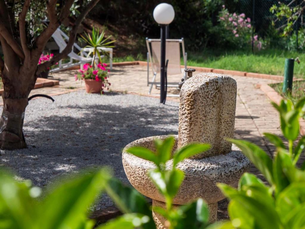 einen Steinstuhl inmitten eines Gartens in der Unterkunft VILLA ANGELA TRABIA in Trabia