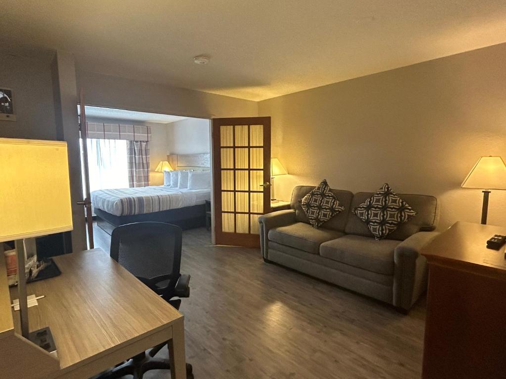 - un salon avec un canapé et un lit dans l'établissement Country Inn & Suites by Radisson, Grand Rapids Airport, MI, à Grand Rapids