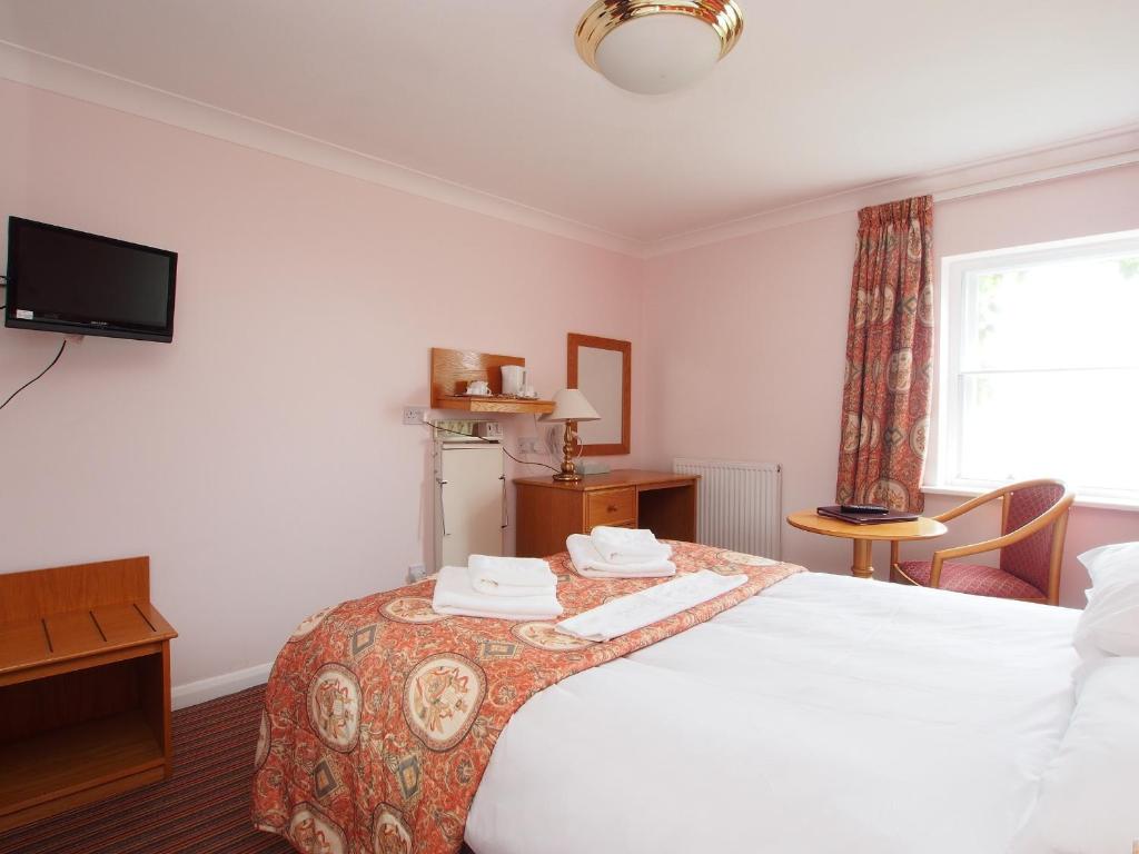 a hotel room with a bed and a television at The Chatsworth Hotel in Worthing