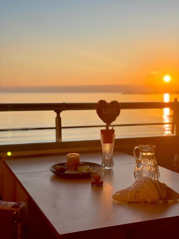 einen Tisch mit einem Teller Essen und einer Vase Blumen in der Unterkunft Cozy Beachfront Room in Durrës