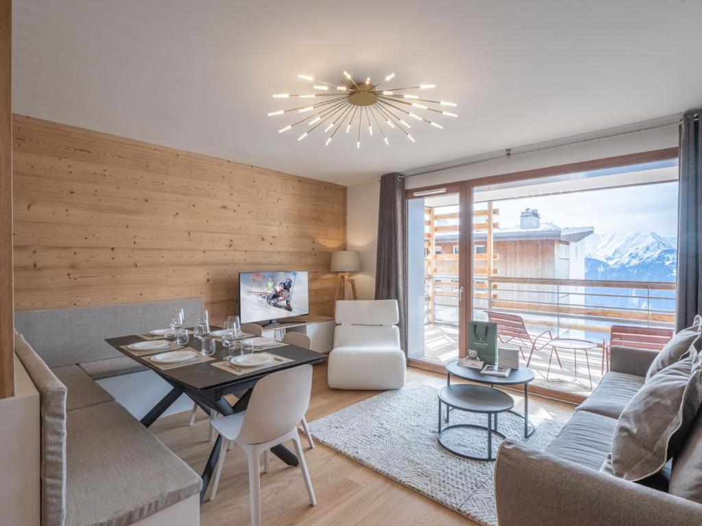 a living room with a table and a couch at Bel appartement neuf 8 pers, proche pistes, parking inclus - FR-1-645-49 in LʼHuez