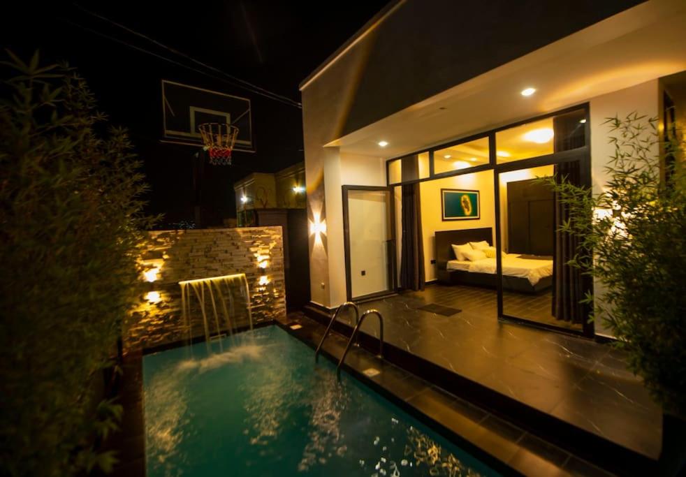 una casa con piscina por la noche en Èze en Kigali