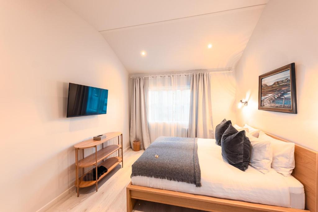 une chambre d'hôtel avec un lit et une télévision dans l'établissement Garður Stay Inn & Secret Lagoon, à Fludir