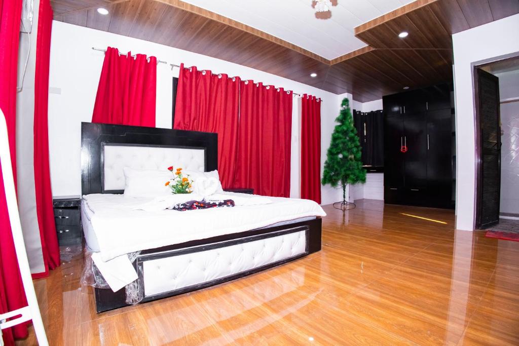 a bedroom with a bed with red curtains and a christmas tree at Villa Valencia Private Resort in Santa Rita
