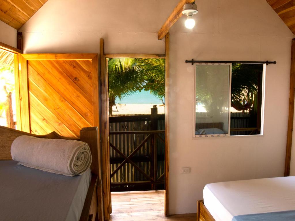 a bedroom with a bed and a view of the beach at Mithival Beach Rincón del Mar in Rincón