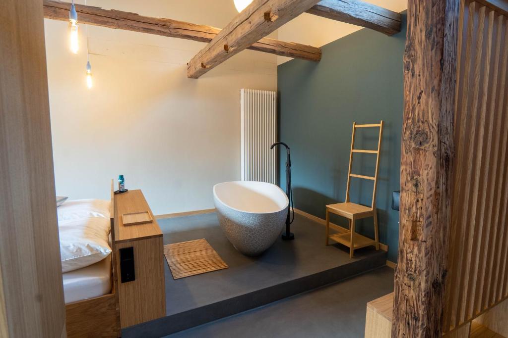 ein Badezimmer mit einer großen Badewanne neben einem Bett in der Unterkunft TIGNUM - Übernachten mit historischem Flair in Wernigerode