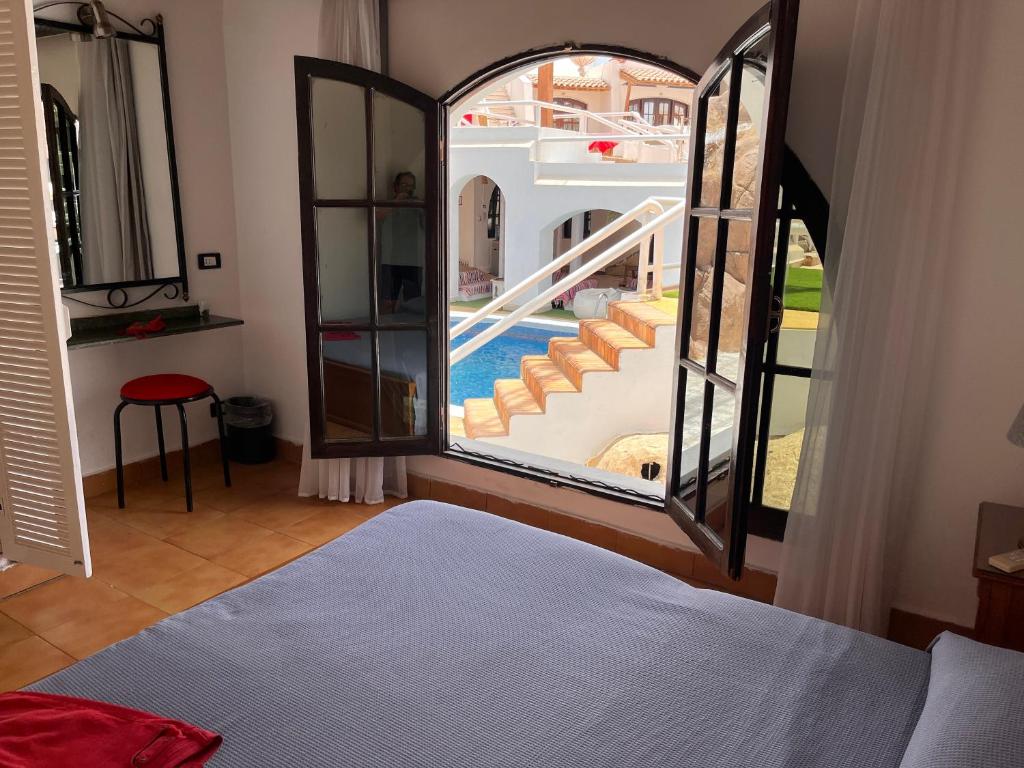 El Pacha Suites Sharm - Adults Only في شرم الشيخ: غرفة نوم بسرير وإطلالة على المسبح