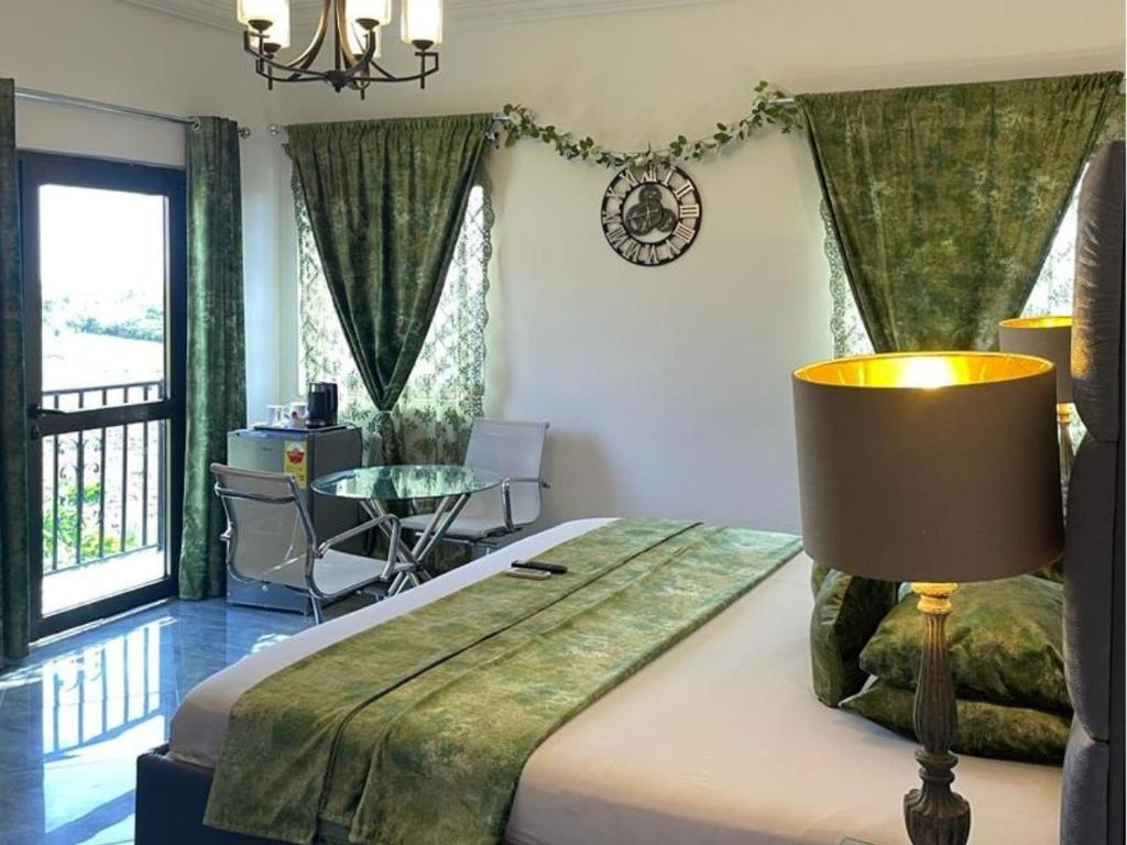 - une chambre avec un lit doté d'une lampe et d'une table dans l'établissement Perriman Hotel, à Kokrobite